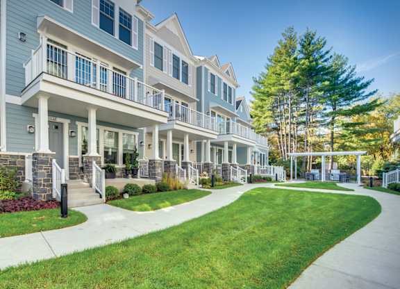 A townhome complex with a grilling station under a pergola in the background.