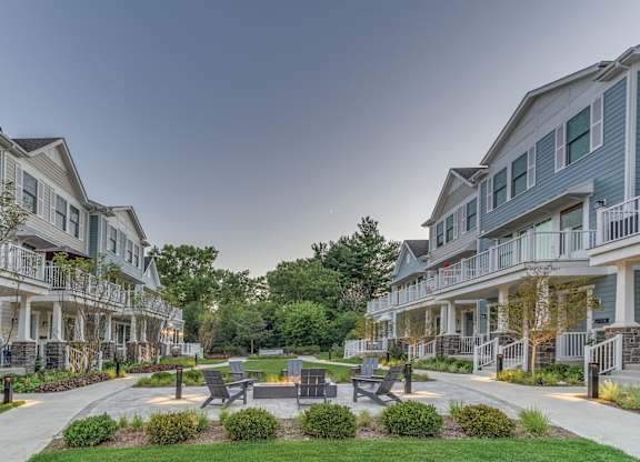 A townhome complex patio with fire pit and chairs on a brick walkway.