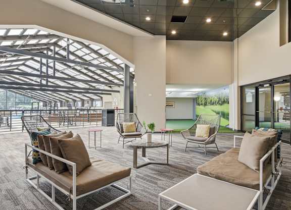 A modern outdoor seating area with a glass wall and a metal roof.
