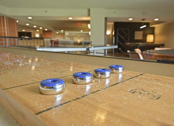 A shiny pool table with blue and silver coins on it.