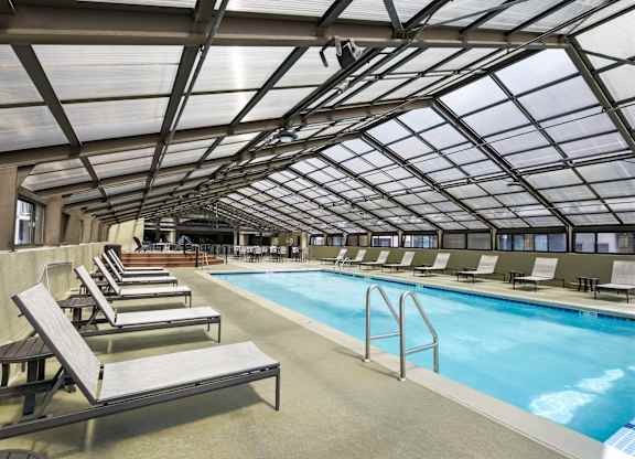 A large indoor swimming pool with sun loungers.