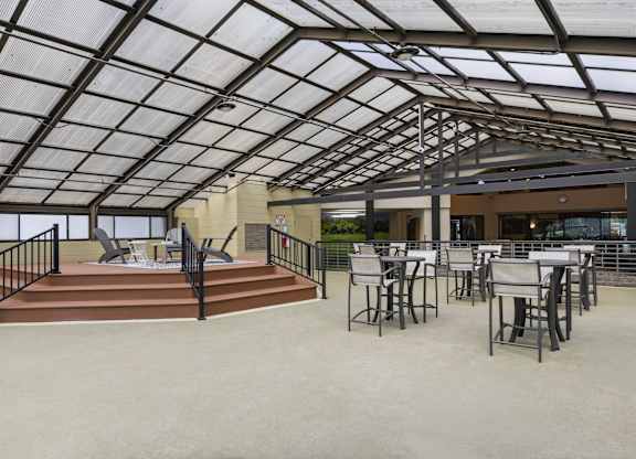 A patio with a black metal railing and a glass roof.