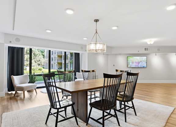 A dining room with a wooden table and chairs.