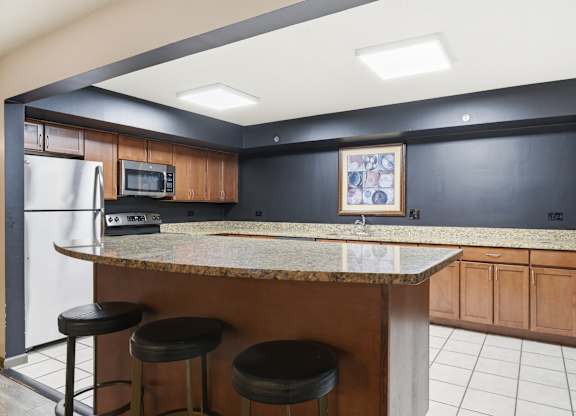 A kitchen with a bar counter and stools.
