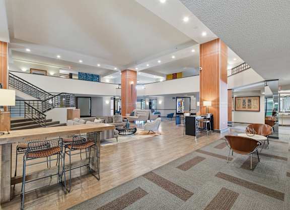 A spacious lobby with a staircase and a bar area.