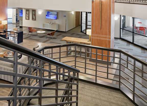 A staircase with a metal railing leads to a second floor.