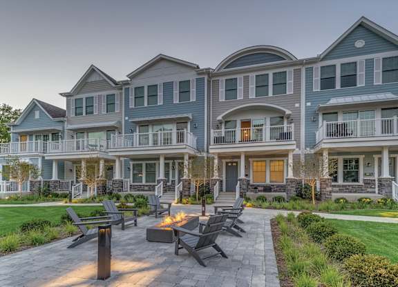 A townhome complex patio with fire pit and chairs on a brick walkway.