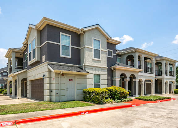 A large, modern house with a red "No Parking" sign in front.