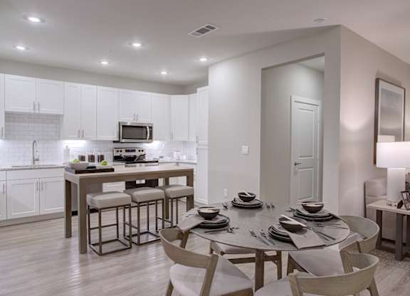 A modern kitchen with a dining table set for four.