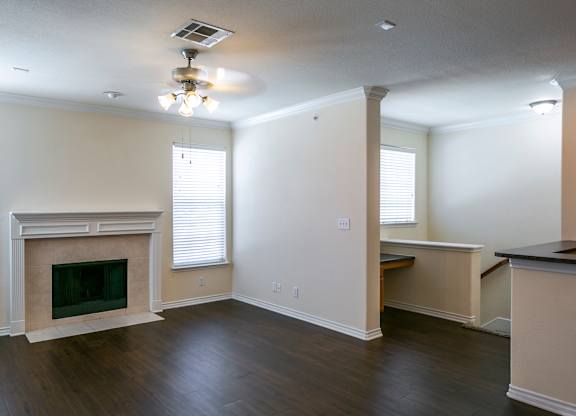 A living room with a fireplace and a ceiling fan.