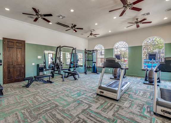 A gym with treadmills, weights, and exercise equipment.