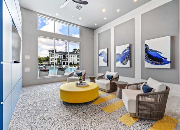 A living room with a yellow coffee table and two chairs.