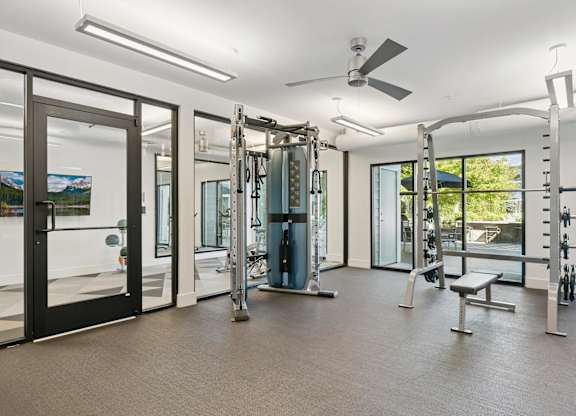 A gym with a variety of equipment including a squat rack, bench, and weights.