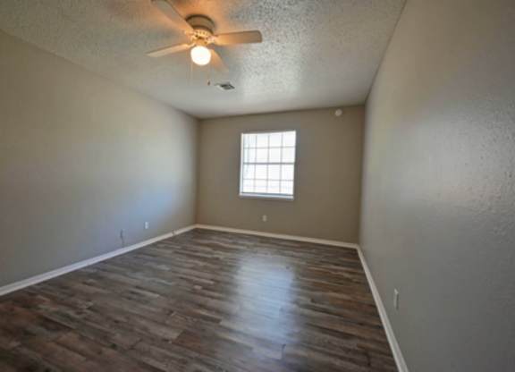 A room with a ceiling fan and a window.