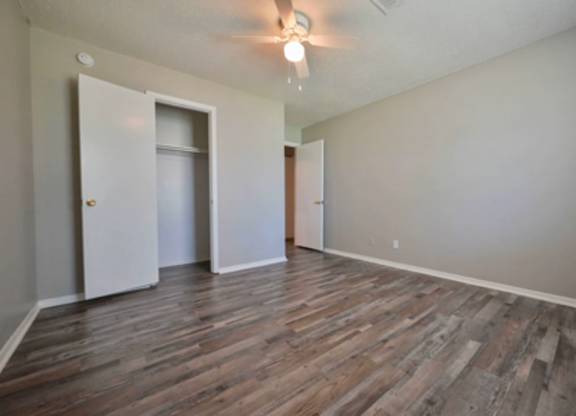 A room with wooden flooring and two doors.