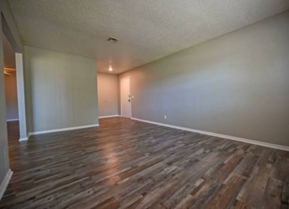 A room with wooden flooring and white walls.