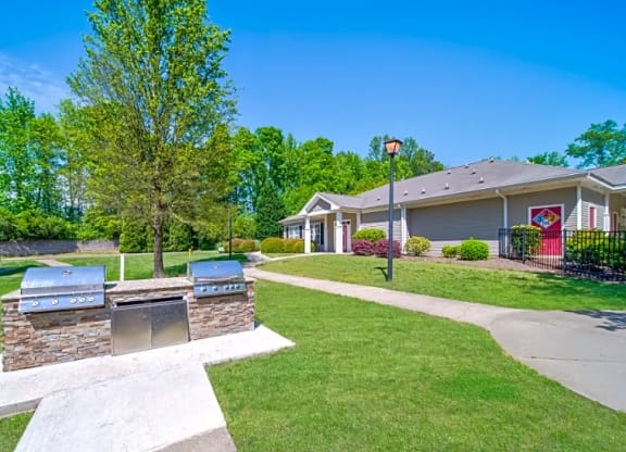 a patio with two barbecue pits in front of a house
