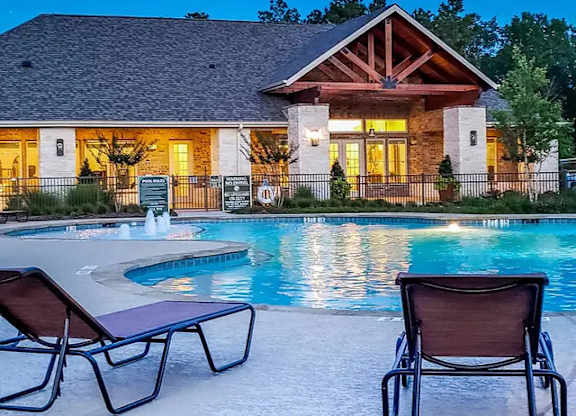 A house with a pool in front of it.