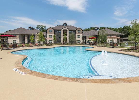 A large swimming pool with a fountain in the middle of it.