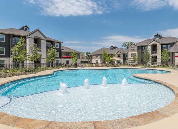 A large swimming pool with a fountain in the middle of it.
