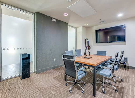 A conference room with a wooden table and chairs.
