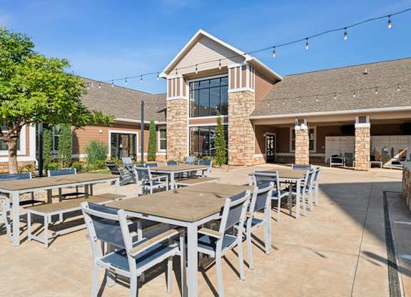 A patio with tables and chairs is set up outside a building.