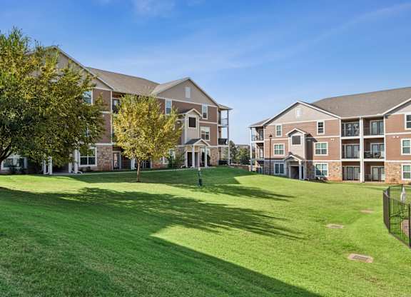 A large grassy area in front of apartment buildings.