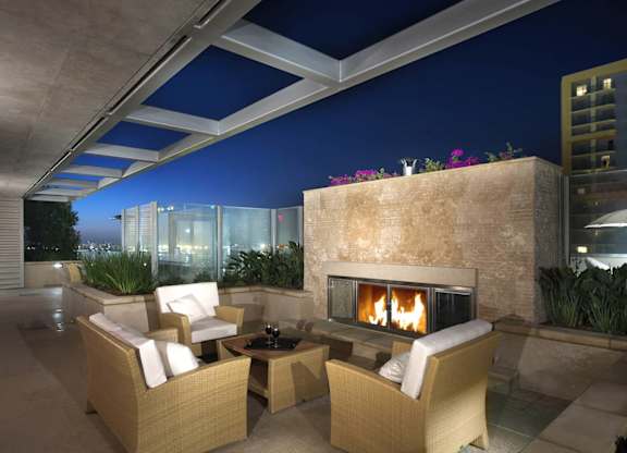 a fireplace on the terrace of a luxury condo at night