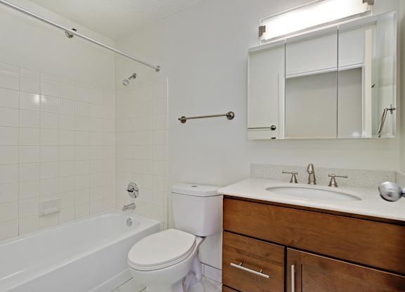 A white bathroom with a toilet, sink, and bathtub.