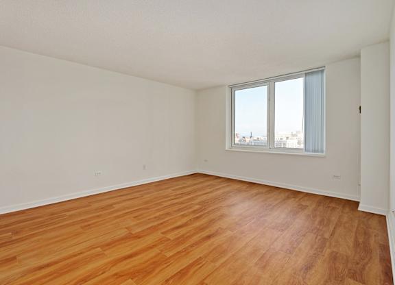 Empty room with wooden floor and a window.