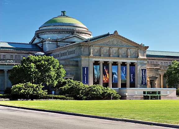 A large building with a green dome and a long row of windows.
