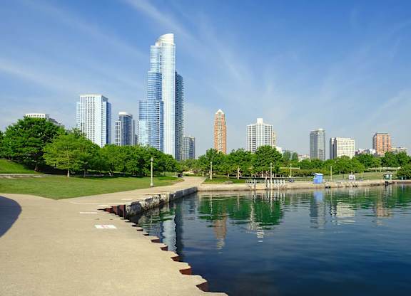 A city skyline is reflected in the water.