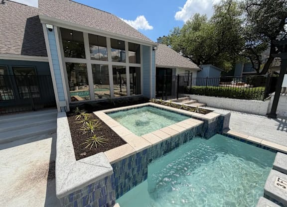 A small pool with a stone border and a concrete floor.