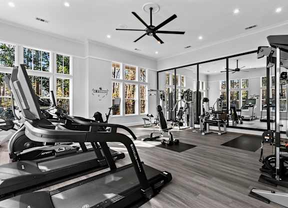 A gym with treadmills, weights, and exercise equipment.
