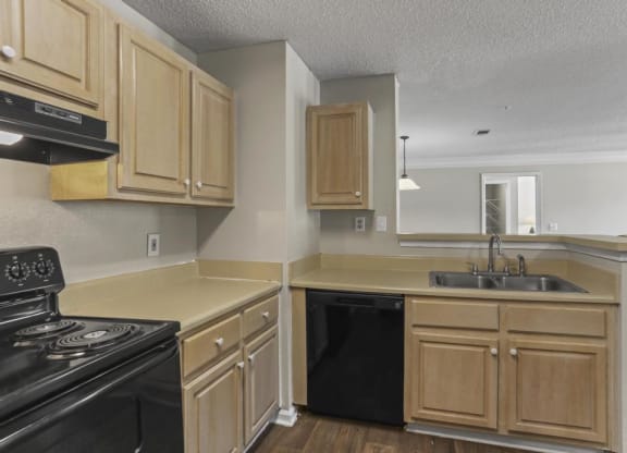 an empty kitchen with wooden cabinets and black appliances