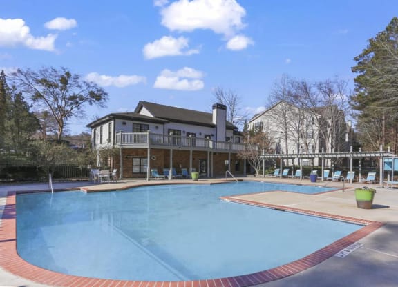 a large swimming pool with a house in the background