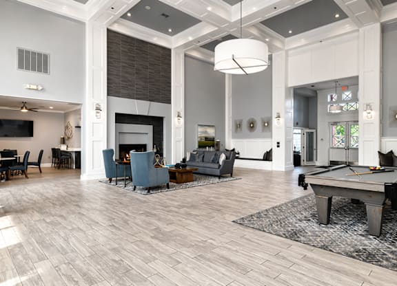 A large, well-lit room with a pool table and a fireplace.