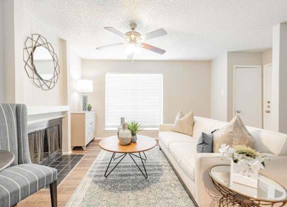 a living room with a fireplace and a ceiling fan