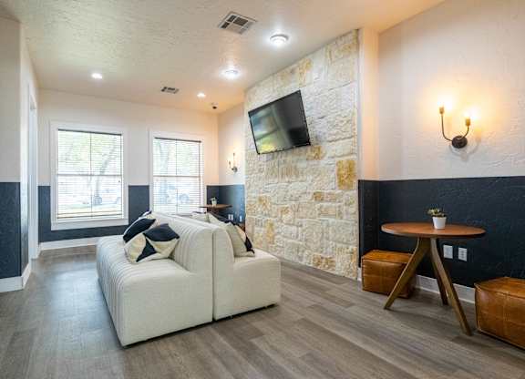 A living room with a white couch and a stone wall.