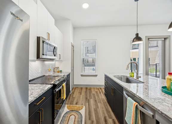 A modern kitchen with a white fridge and black cabinets.