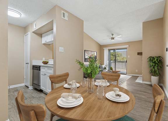 A dining room with a table set for two with a view of the backyard.