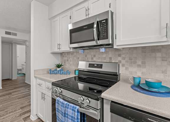 A kitchen with a stove top oven and a microwave above it.