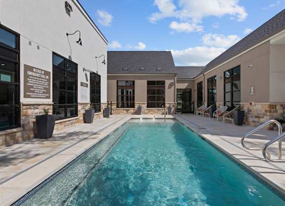 A swimming pool in a sunny outdoor setting.