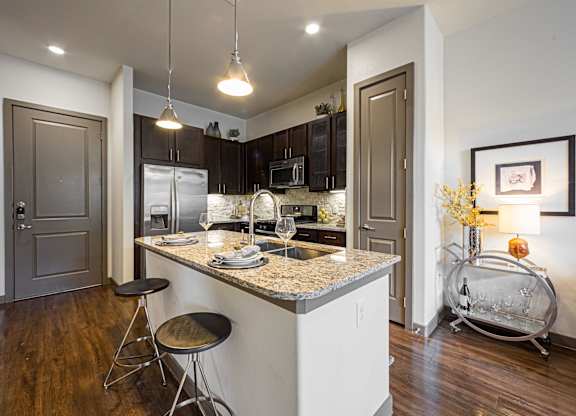 A kitchen with a bar stool and a counter.