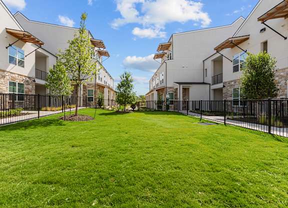 A grassy area in front of a row of houses.