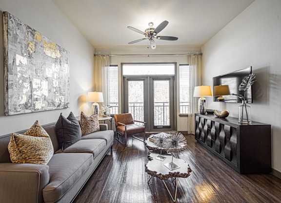 A living room with a grey couch, a coffee table, and a painting on the wall.