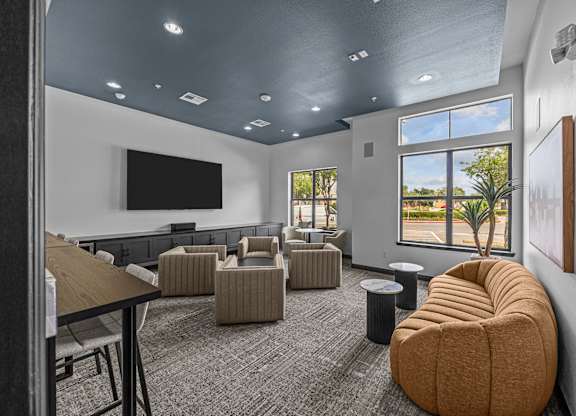 A room with a large window, a flat screen TV, and a comfortable seating area.
