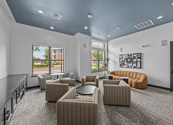 A spacious room with grey carpet and a variety of seating options.
