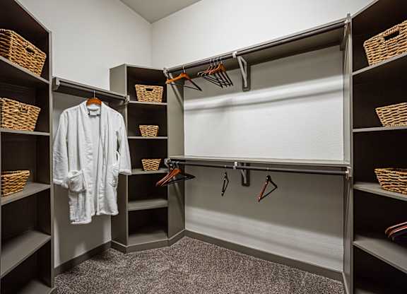 A white shirt is hanging on a hanger in a closet.