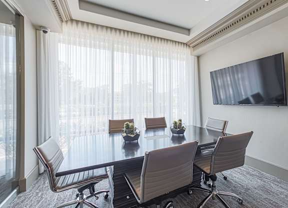 A conference room with a large table and chairs.